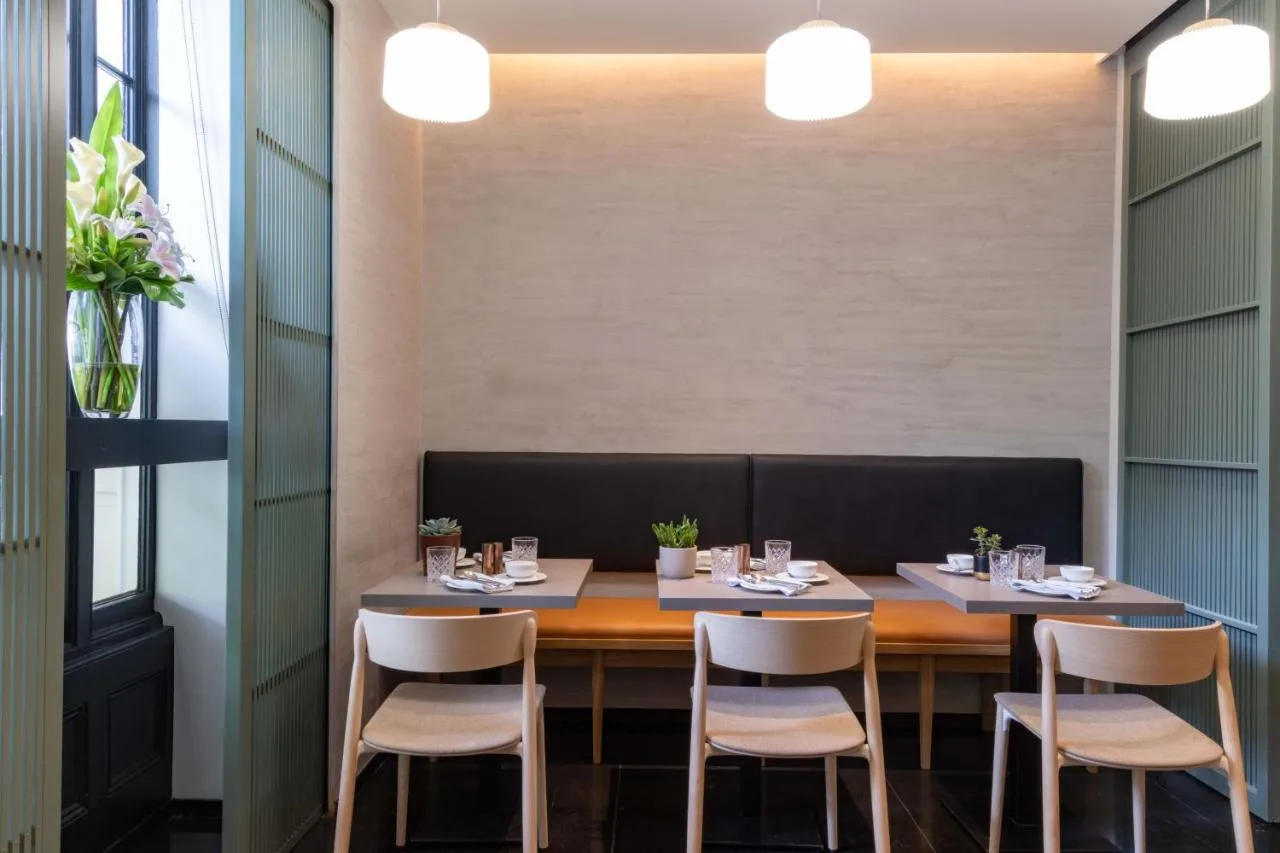 a dining room with a table and chairs at La Suite West - Hyde Park in London